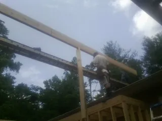 Carpenter setting a ridge beam over a new addition frame — Ice Dam Removal by Roofing Brothers in Tekamah