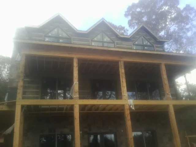 Dormers and porch framing on a large log home under construction — Roof Coating work by our crew in Tekamah