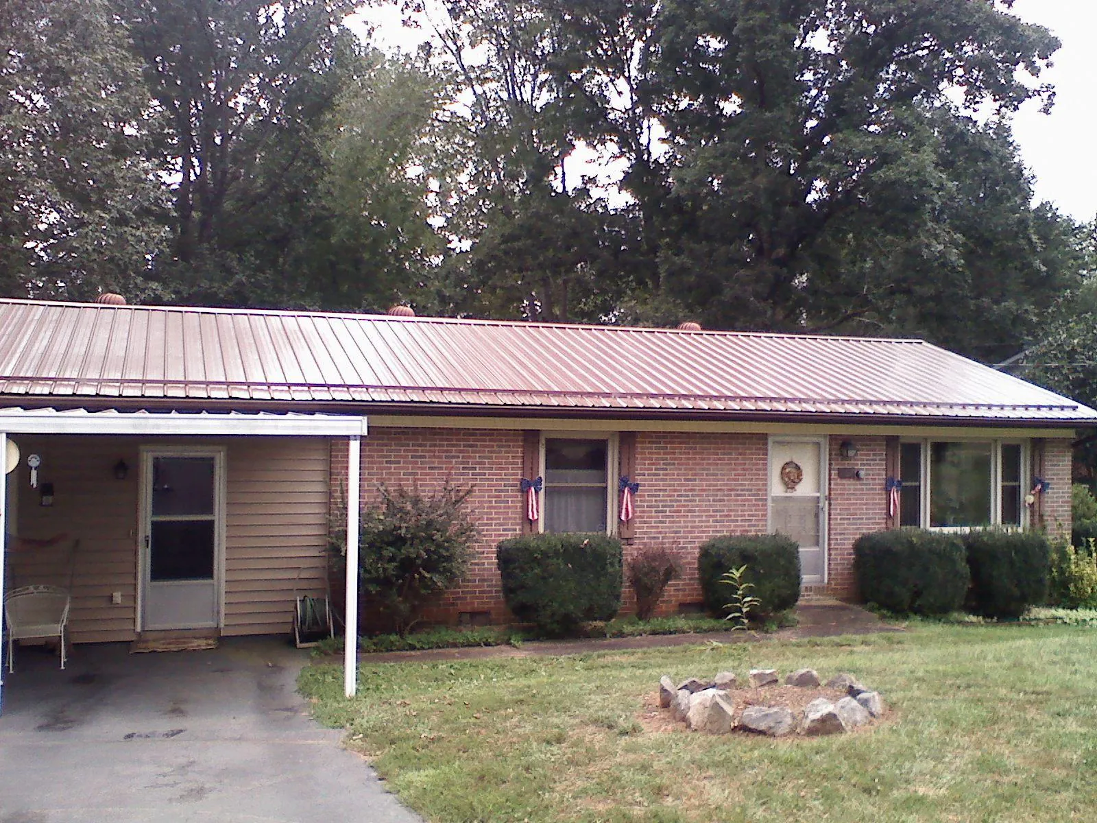 Bronze metal roof and carport on a brick ranch home — Roof Repair work by our crew in Tekamah